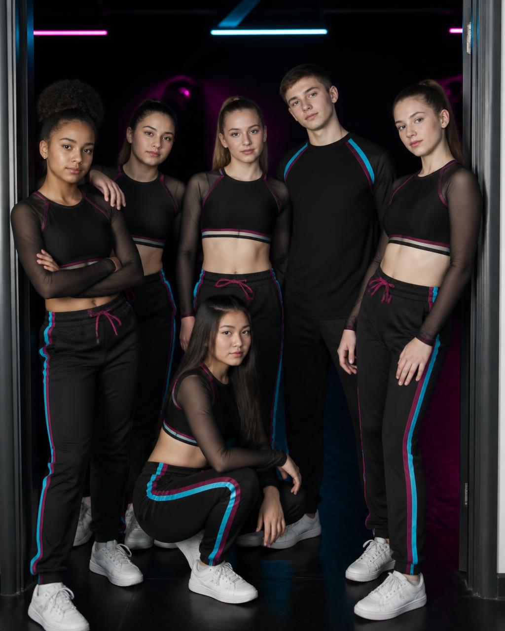 A competitive dance team posing together at their studio